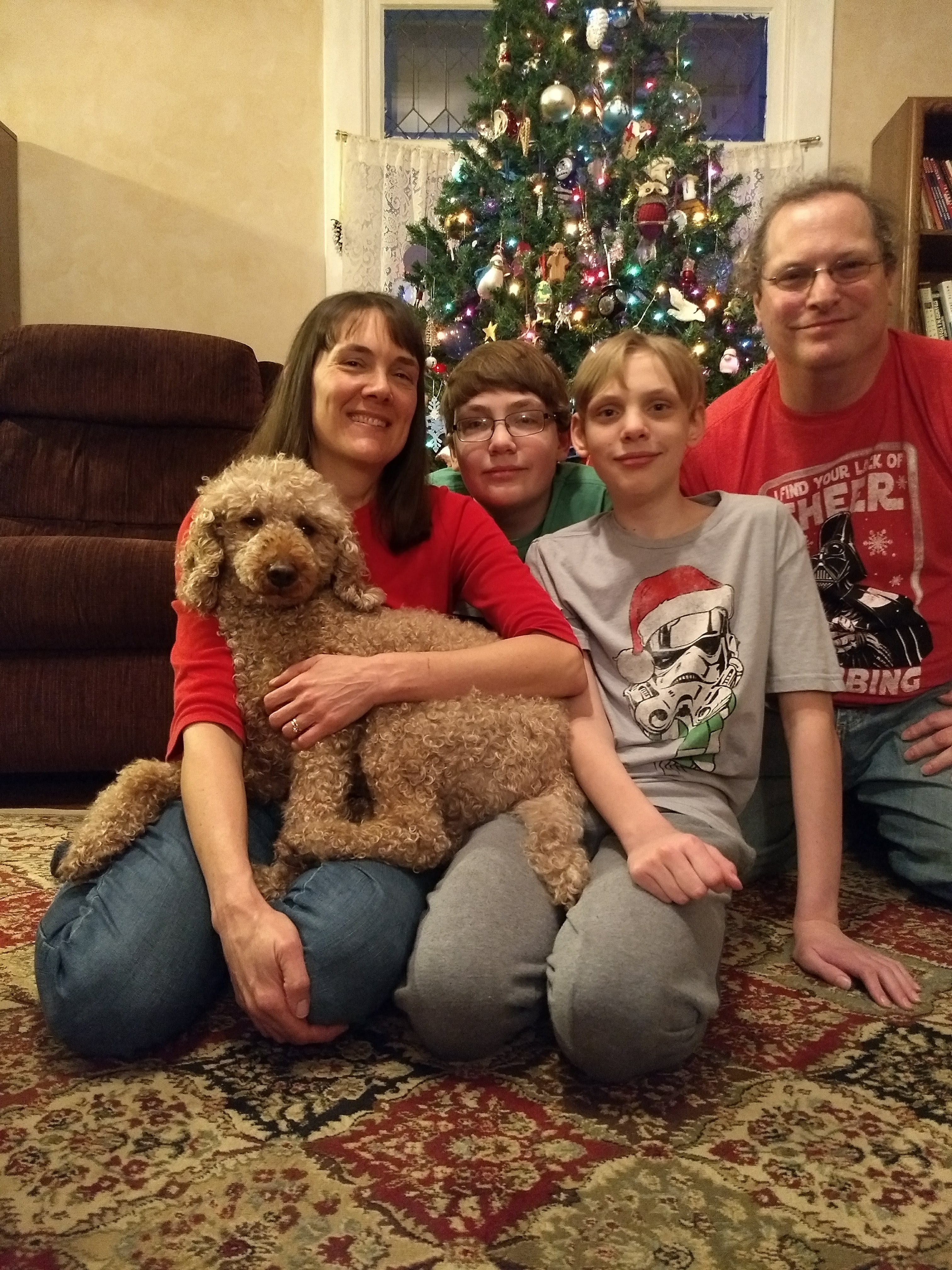 Family around Christmas tree with dog